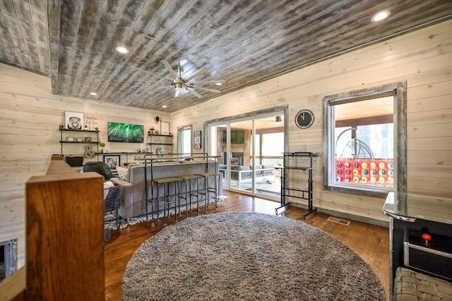 living room with dark hardwood / wood-style floors and wooden walls