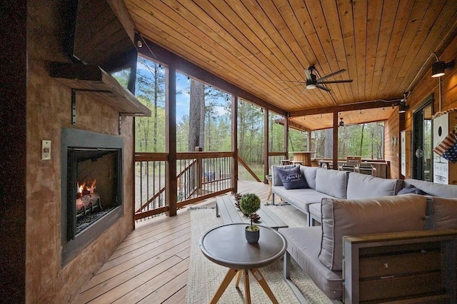 sunroom / solarium with ceiling fan, wood ceiling, and vaulted ceiling