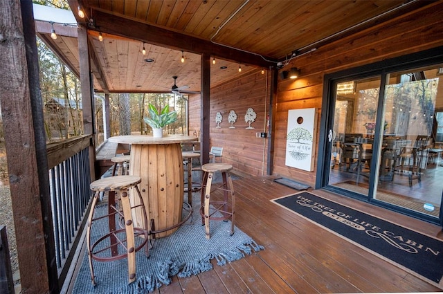 wooden terrace with ceiling fan and exterior bar