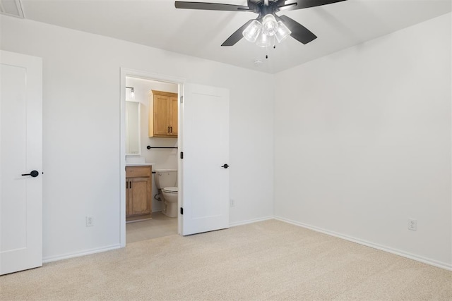 unfurnished bedroom with light carpet, ensuite bathroom, and ceiling fan