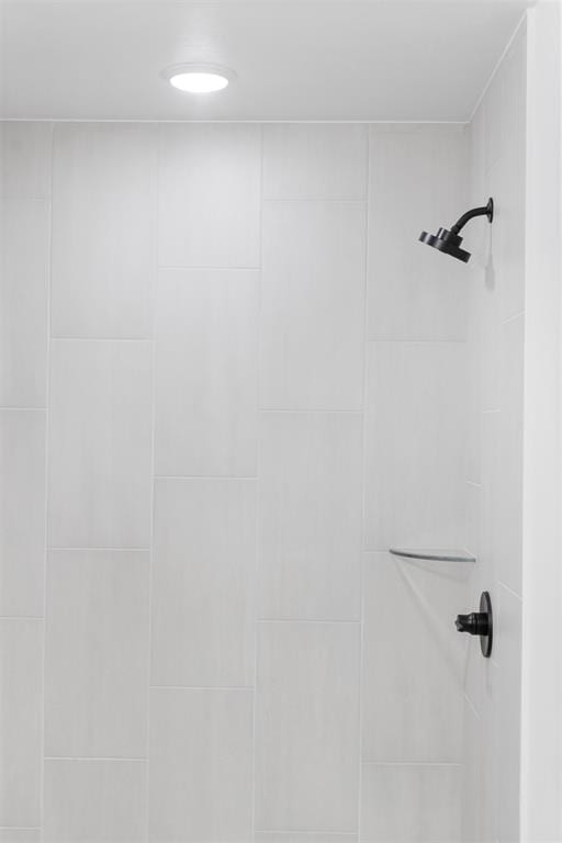 interior details featuring a tile shower