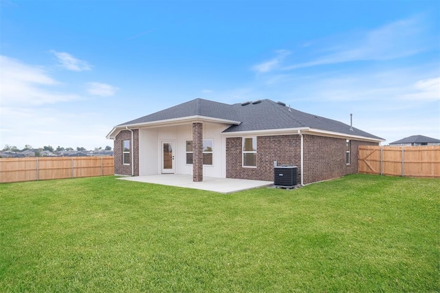 rear view of house with central AC unit, a patio, and a lawn