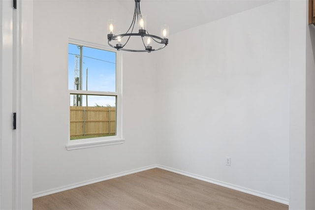 unfurnished dining area with a chandelier and light hardwood / wood-style flooring