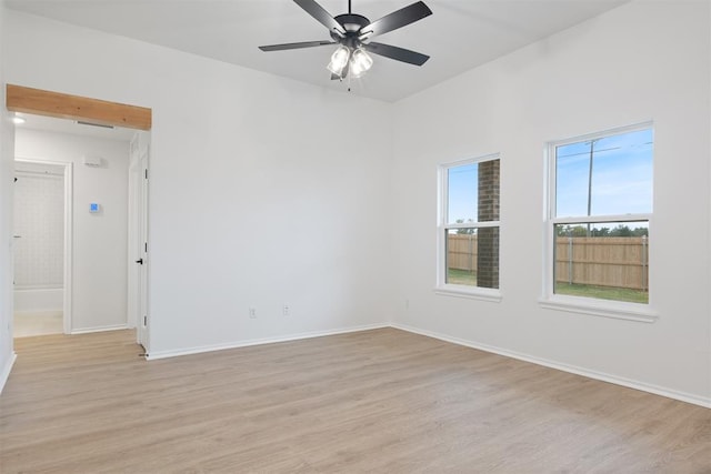 empty room with ceiling fan and light hardwood / wood-style flooring