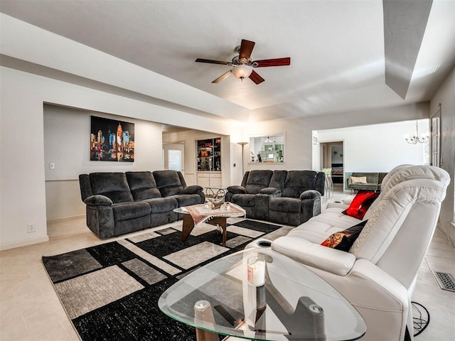 tiled living room with ceiling fan with notable chandelier