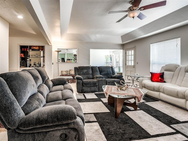 living room featuring a raised ceiling and ceiling fan