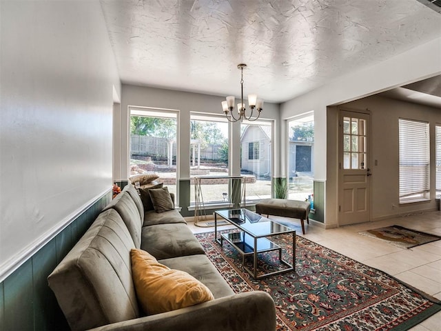 tiled living room featuring a chandelier and a textured ceiling