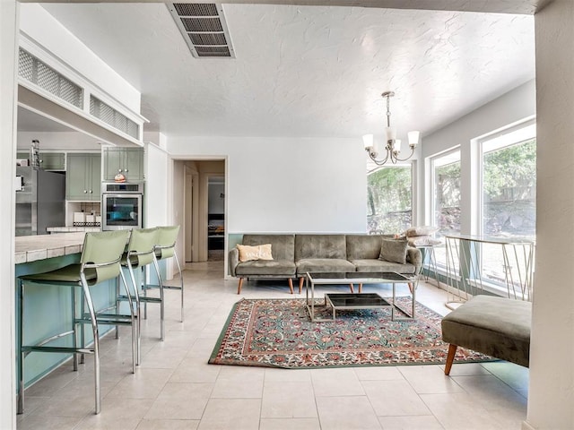 tiled living room featuring a notable chandelier and a textured ceiling