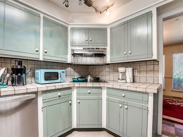 kitchen featuring backsplash, track lighting, stainless steel gas cooktop, and tile counters