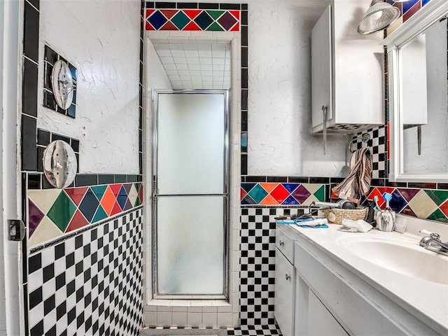 bathroom featuring vanity, walk in shower, and tile walls