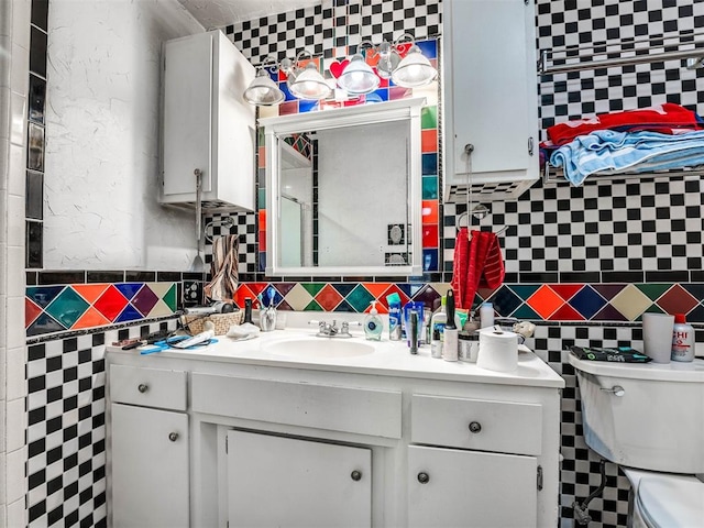 bathroom with vanity, toilet, and tile walls