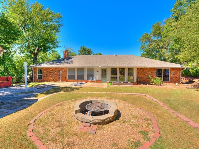 view of front of house featuring a front lawn and a fire pit