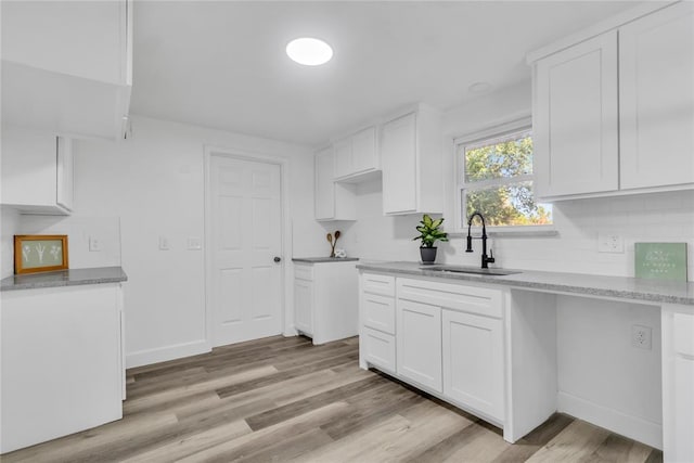 kitchen featuring white cabinetry, sink, and light hardwood / wood-style flooring