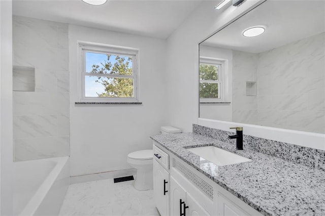 full bathroom featuring tiled shower / bath, vanity, and toilet