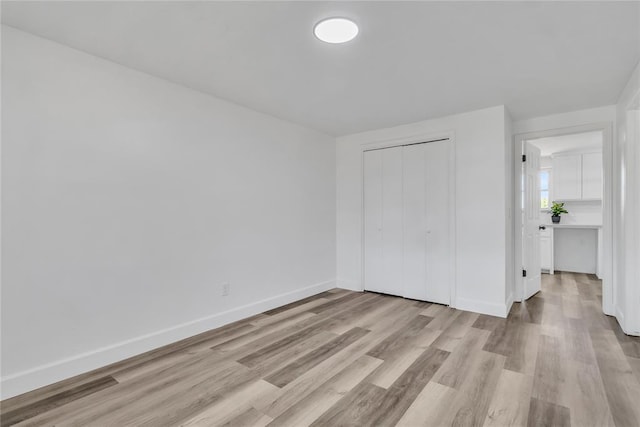 unfurnished bedroom with light hardwood / wood-style floors and a closet