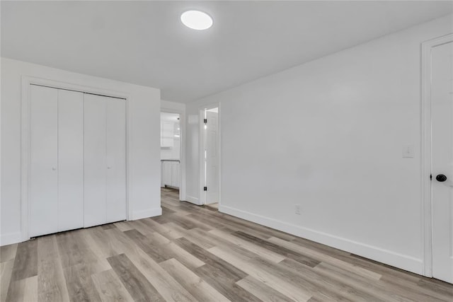 unfurnished bedroom featuring a closet and light hardwood / wood-style flooring