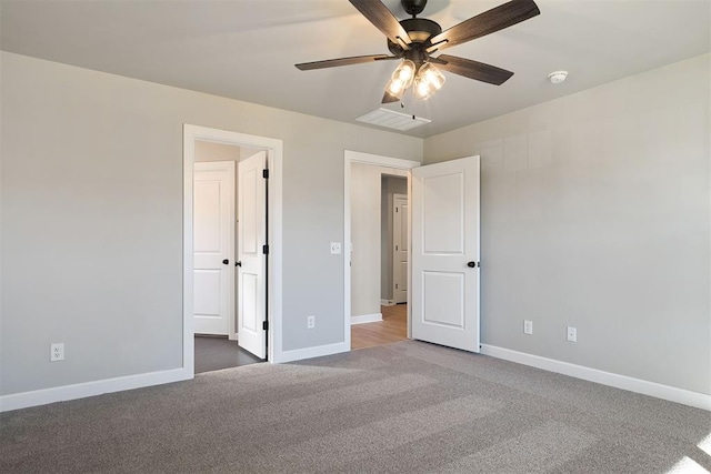 unfurnished bedroom with ceiling fan and dark carpet