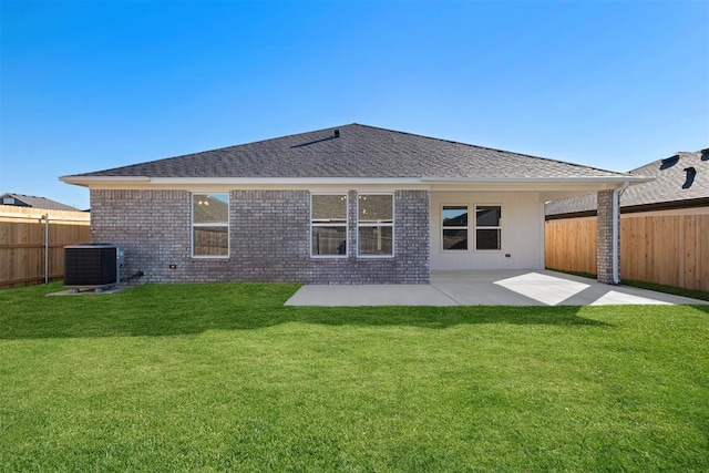 rear view of property with a lawn, a patio area, and central air condition unit