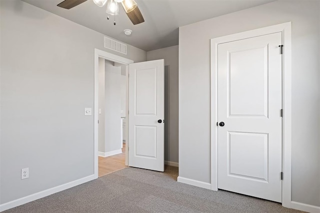 unfurnished bedroom featuring ceiling fan and light carpet