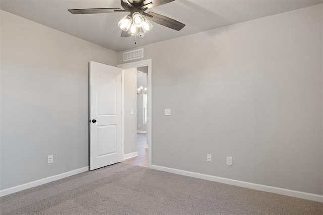 carpeted spare room featuring ceiling fan