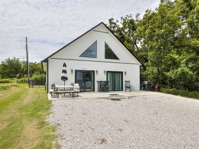 rear view of house featuring a lawn and a patio area