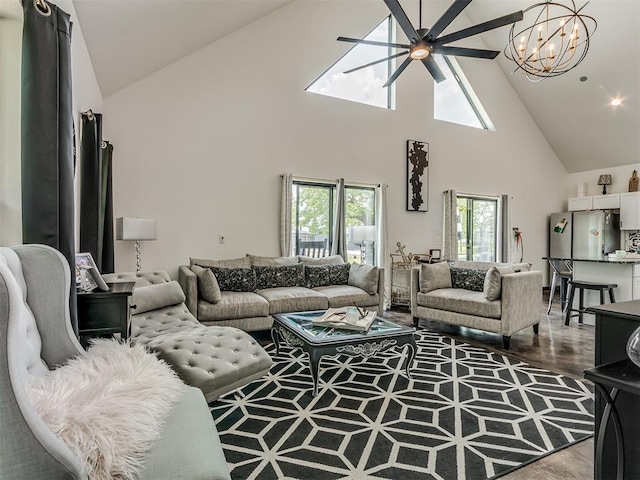 living room featuring hardwood / wood-style floors, ceiling fan with notable chandelier, high vaulted ceiling, and a wealth of natural light