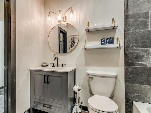 bathroom featuring vanity, toilet, and a tub