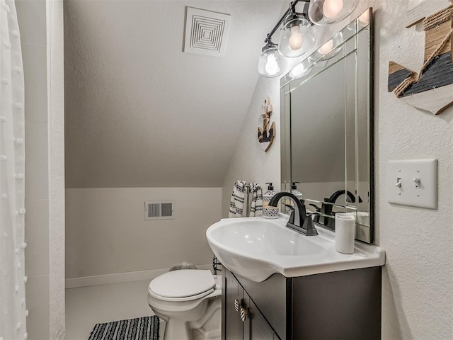 bathroom with vanity, toilet, lofted ceiling, and walk in shower