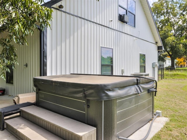 exterior space with a yard, a hot tub, and cooling unit