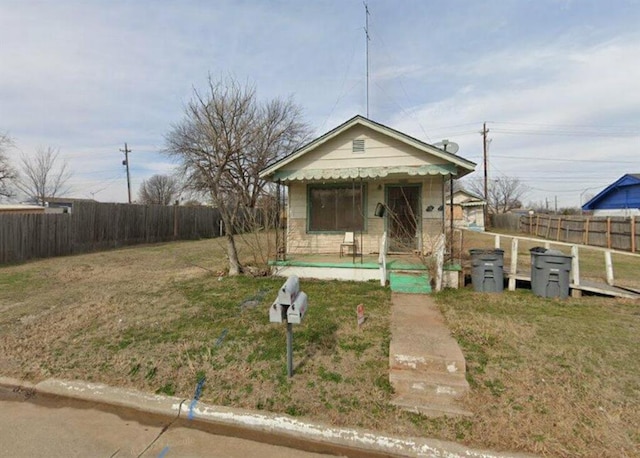 bungalow featuring covered porch and a front yard