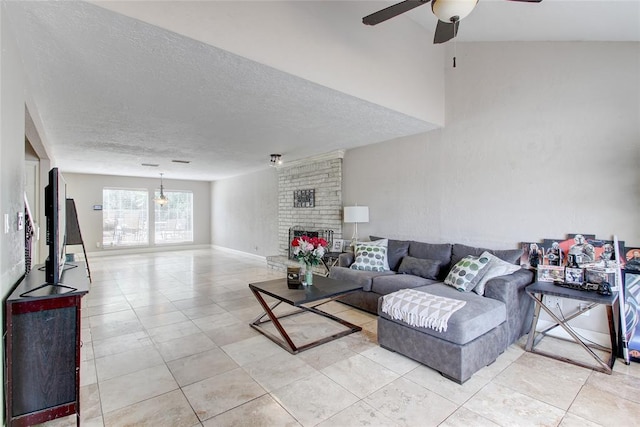 living room with a fireplace, light tile patterned floors, a textured ceiling, and ceiling fan