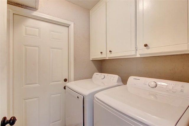 washroom featuring cabinets and independent washer and dryer