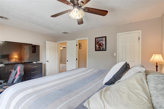 bedroom with ceiling fan and a textured ceiling