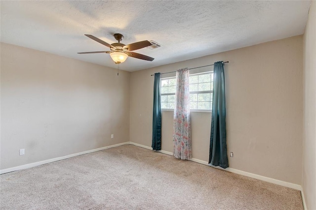 carpeted spare room with ceiling fan and a textured ceiling