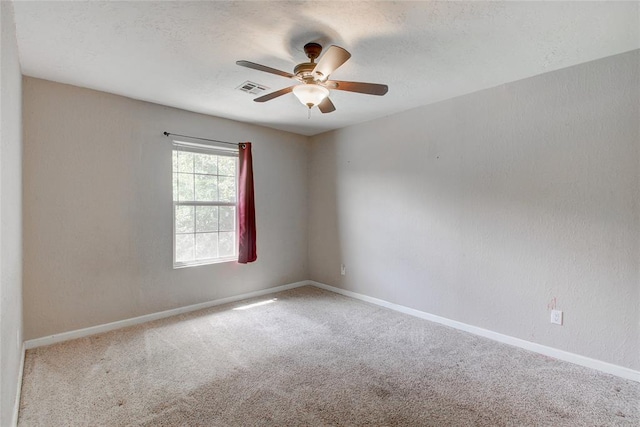 carpeted empty room featuring ceiling fan and a textured ceiling