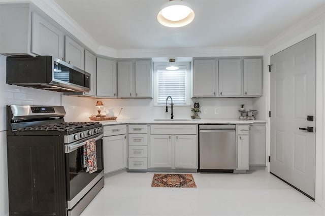 kitchen featuring gray cabinetry, sink, light tile patterned floors, and stainless steel appliances