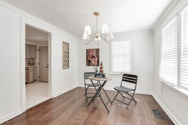 dining area featuring dark hardwood / wood-style flooring, ornamental molding, and a wealth of natural light