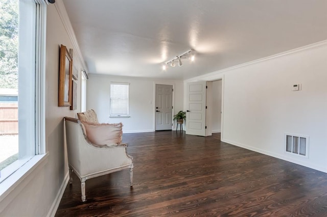 unfurnished room featuring rail lighting, dark hardwood / wood-style floors, and crown molding