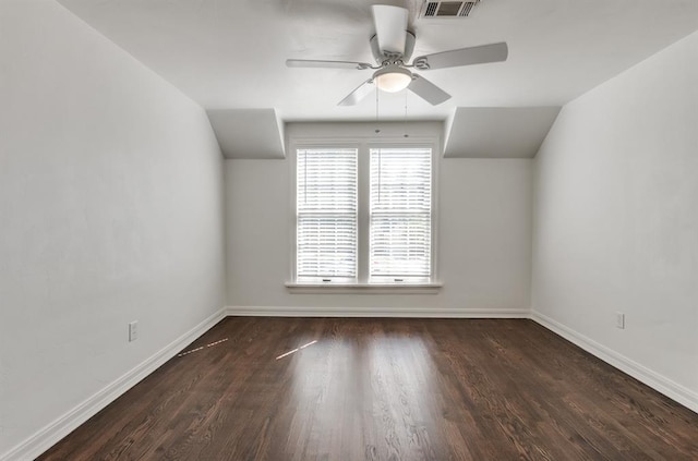 empty room featuring dark hardwood / wood-style floors, vaulted ceiling, and ceiling fan