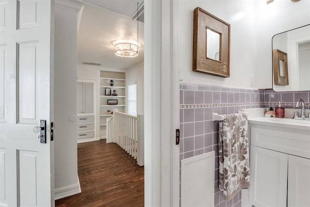 bathroom featuring wood-type flooring, vanity, and tile walls