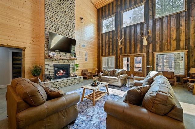 living room featuring wood walls, high vaulted ceiling, and a healthy amount of sunlight