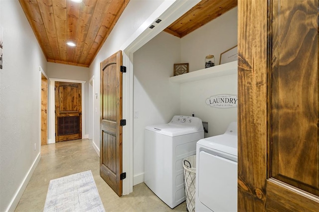 clothes washing area with washing machine and dryer and wooden ceiling