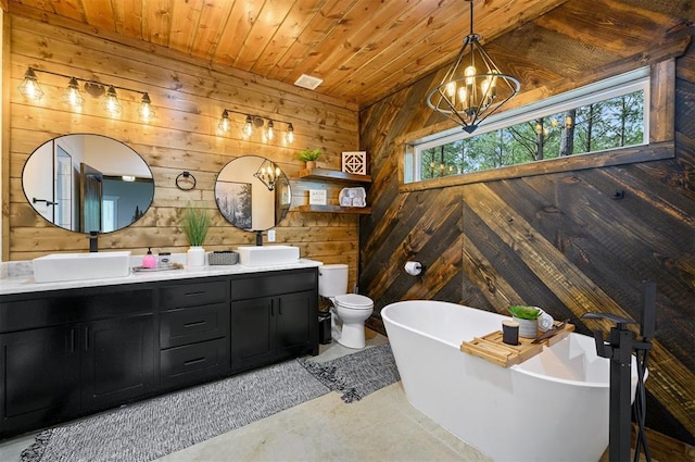 bathroom featuring wooden walls, concrete floors, a healthy amount of sunlight, and a notable chandelier