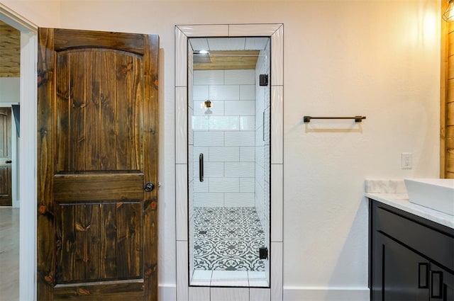 bathroom featuring a shower with door and vanity