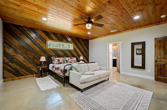 bedroom featuring ceiling fan, wood walls, ensuite bathroom, concrete flooring, and wood ceiling