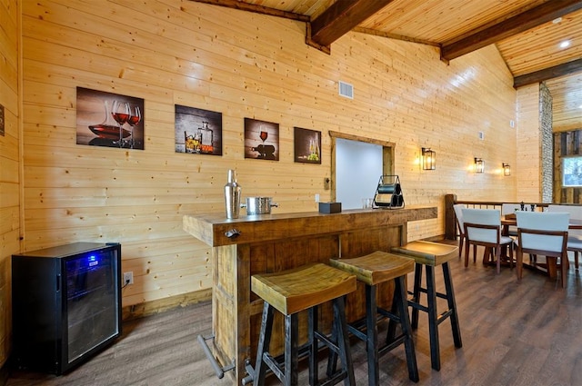 bar featuring wood ceiling, wood walls, beamed ceiling, and dark wood-type flooring