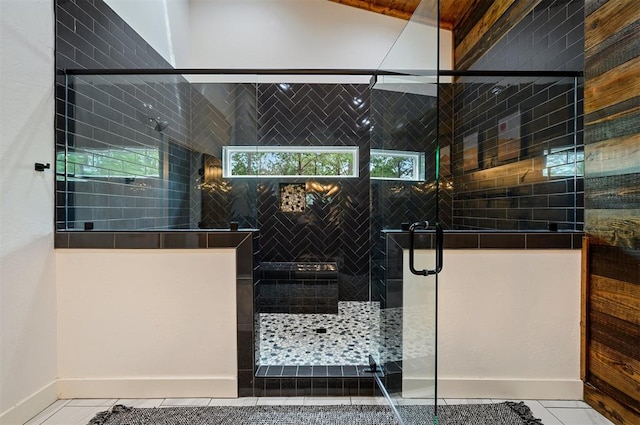 bathroom with a shower with door, tile patterned flooring, and a healthy amount of sunlight