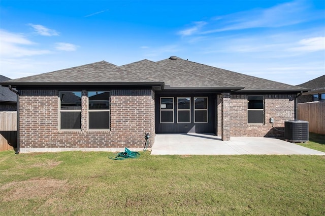 rear view of house with a lawn, a patio area, and central AC