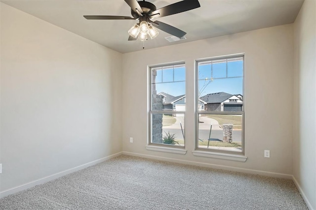 carpeted spare room featuring ceiling fan