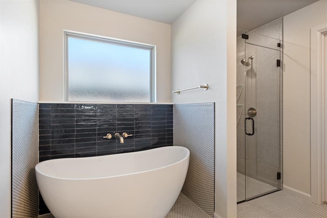 bathroom with tile patterned flooring, separate shower and tub, and tile walls